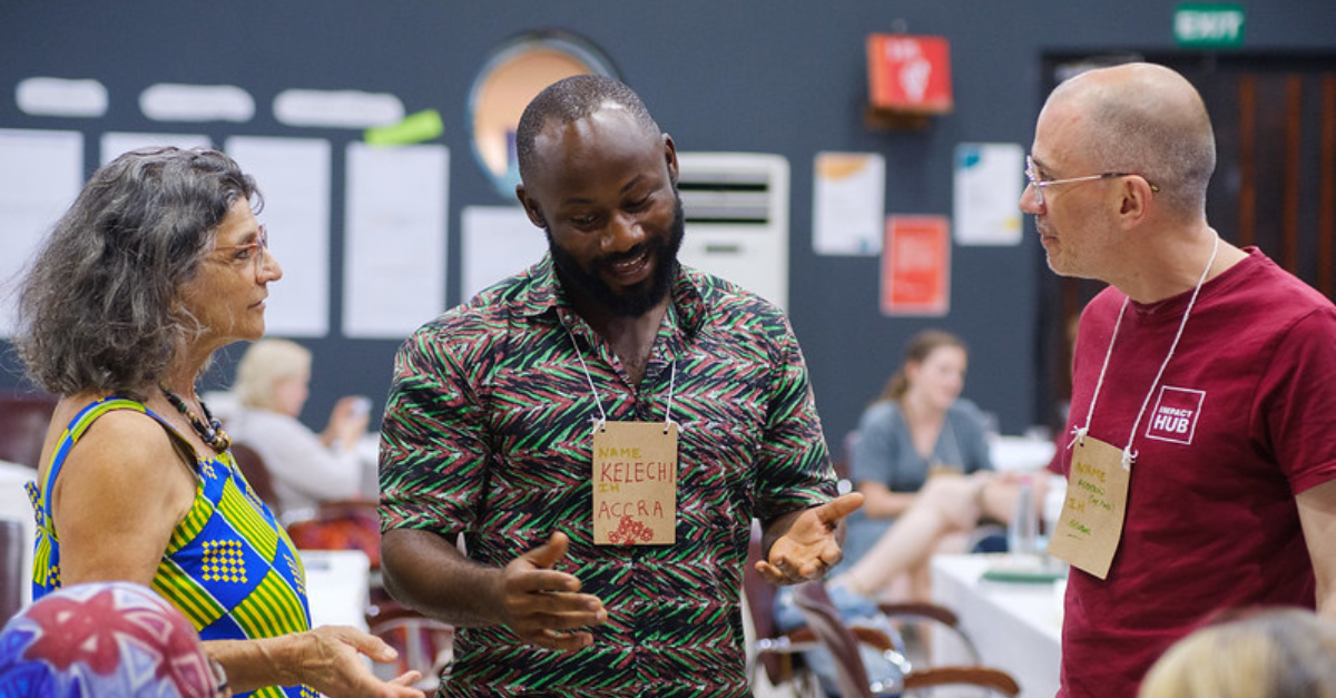 homem conversando e gesticulando com uma mulher e outro homem