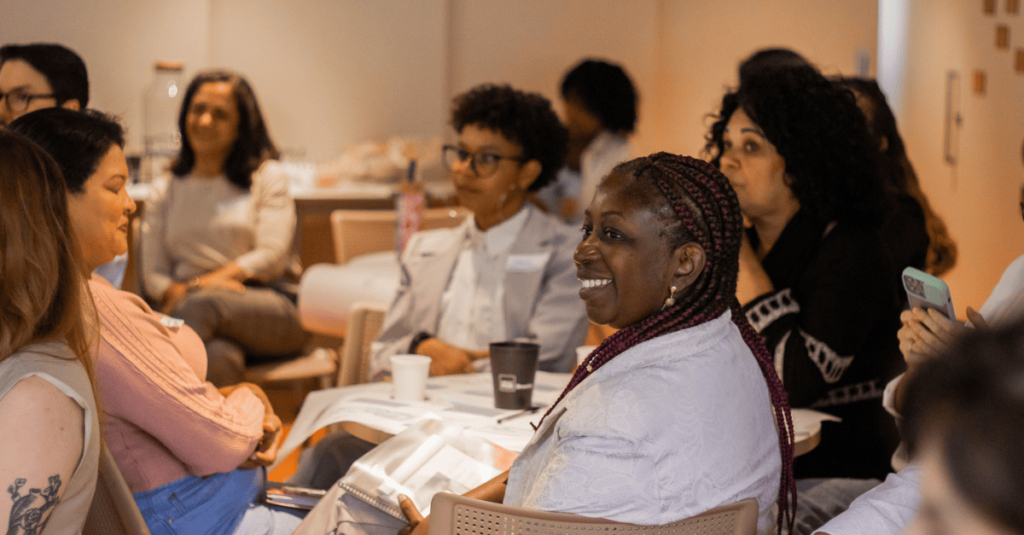 mulheres diversas em mesa rindo e conversando