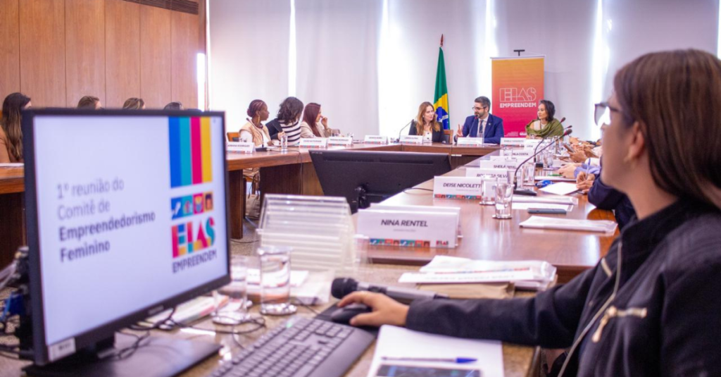 computador desfocada na frente e reunião ao fundo