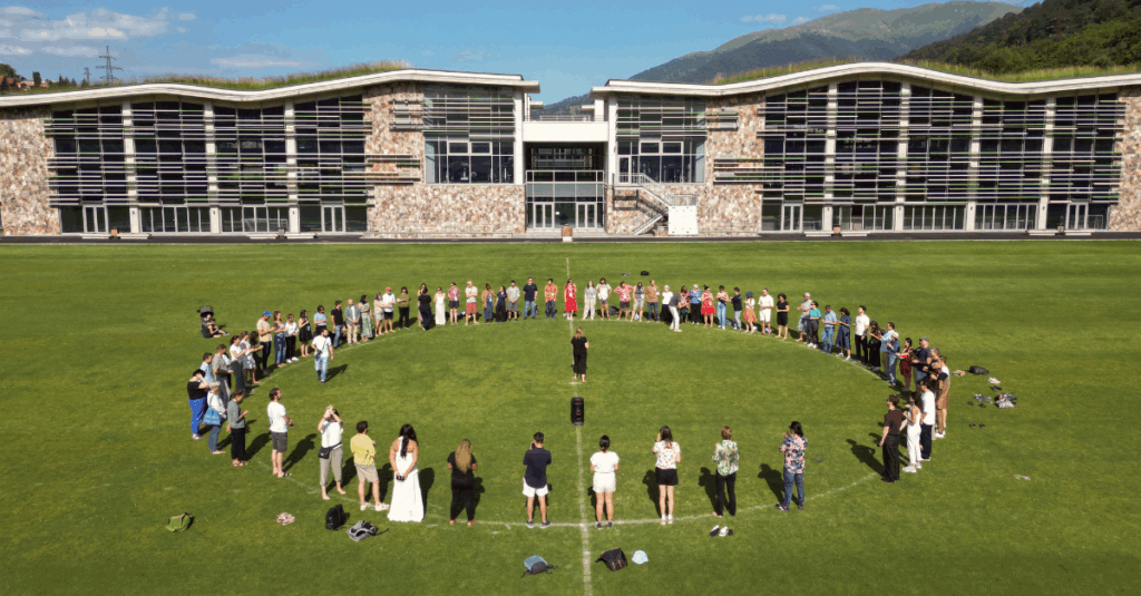 diversas pessoas reunidas em círculo em um campo de futebol